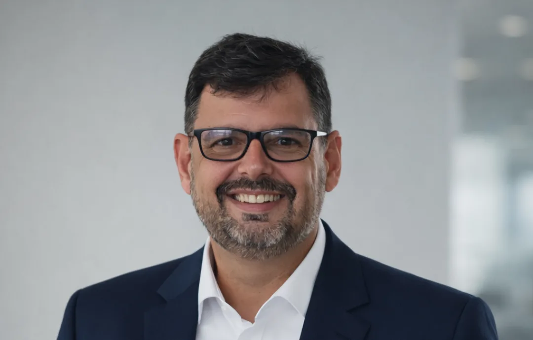 Stênio Duarte, fundador da Vixio, de óculos, camisa branca e paletó azul-marinho, sorrindo.